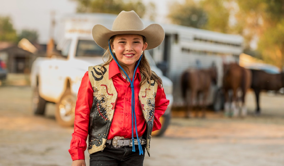 Portrait of a young, dressed up, ready to ride cowgirl